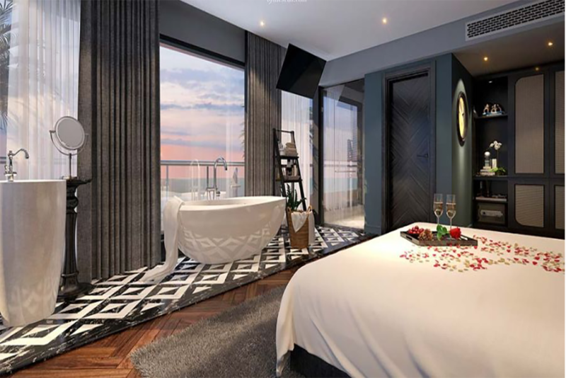 Luxurious bedroom with romantic decor, a bathtub, and stunning sunset views of Ha Long Bay on the Elite of the Seas Cruise.