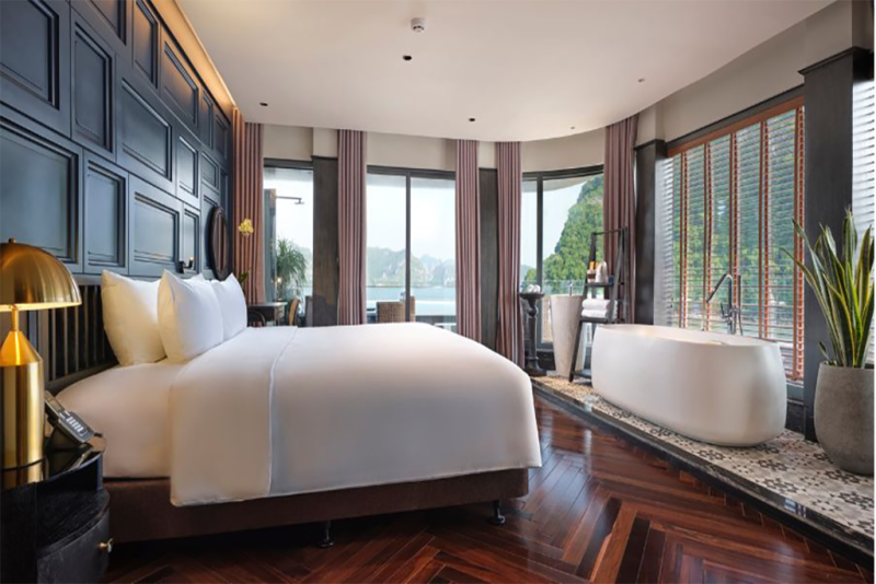 Luxurious bedroom with modern amenities and a bathtub offering stunning views of Ha Long Bay on the Elite of the Seas Cruise.