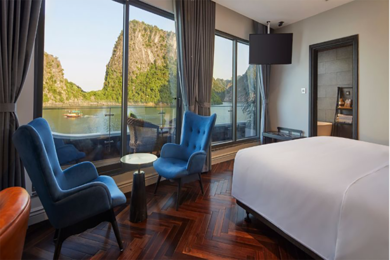 Luxurious bedroom with elegant decor and panoramic views of Ha Long Bay on the Elite of the Seas Cruise.