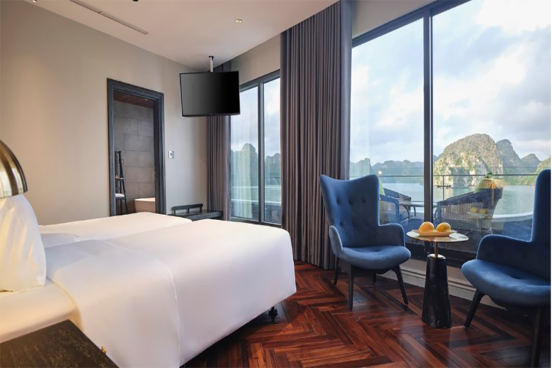 Luxurious bedroom with elegant decor and panoramic views of Ha Long Bay on the Elite of the Seas Cruise.