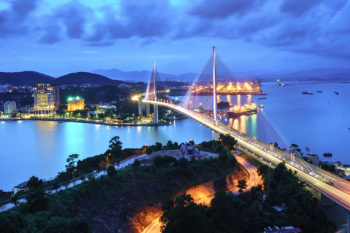 Ha Long Bay at night with illuminated bridge and cityscape