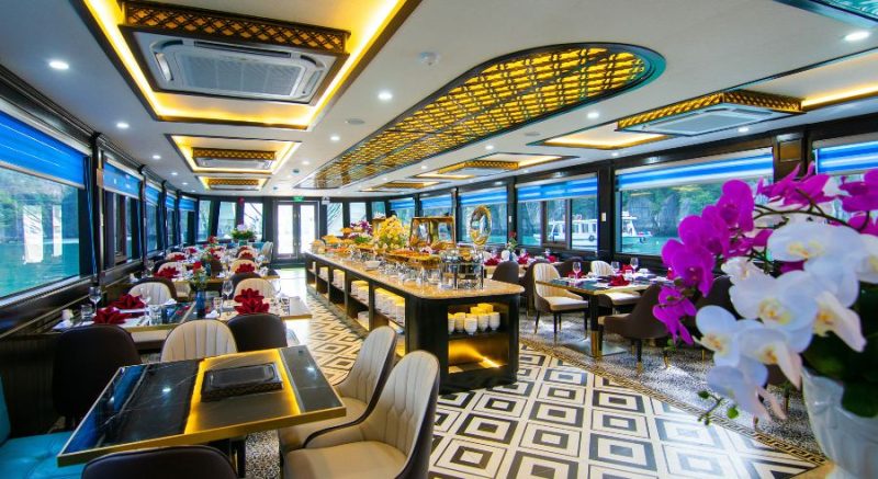 Elegant dining area and buffet setup with floral decorations on La Casta luxury cruise in Ha Long Bay.