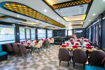 Elegant dining area and buffet setup with floral decorations on La Casta luxury cruise in Ha Long Bay.