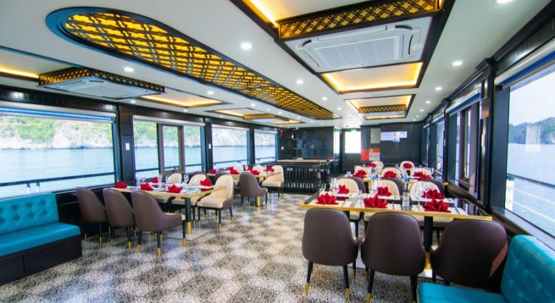 Elegant dining area and buffet setup with floral decorations on La Casta luxury cruise in Ha Long Bay.