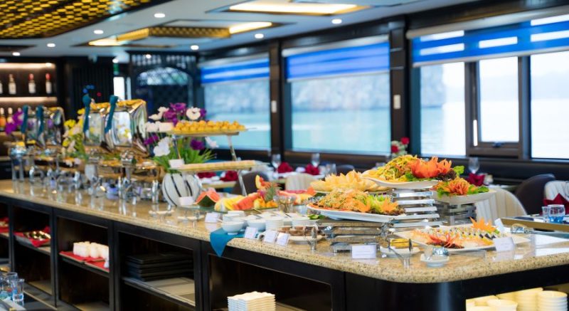 Colorful buffet setup with fresh fruits and dishes on La Casta luxury cruise in Ha Long Bay.