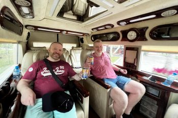 Two happy tourists enjoying the luxurious interior of a limousine van on a Hanoi to Ha Long Bay tour