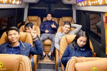 Group of happy tourists enjoying the comfortable interior of a limousine van on a tour from Hanoi to Ha Long Bay