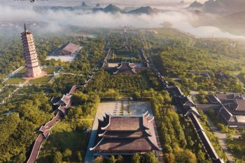 Aerial view of Trang An complex in Ninh Binh with ancient pagodas, lush greenery, and misty mountains in the background