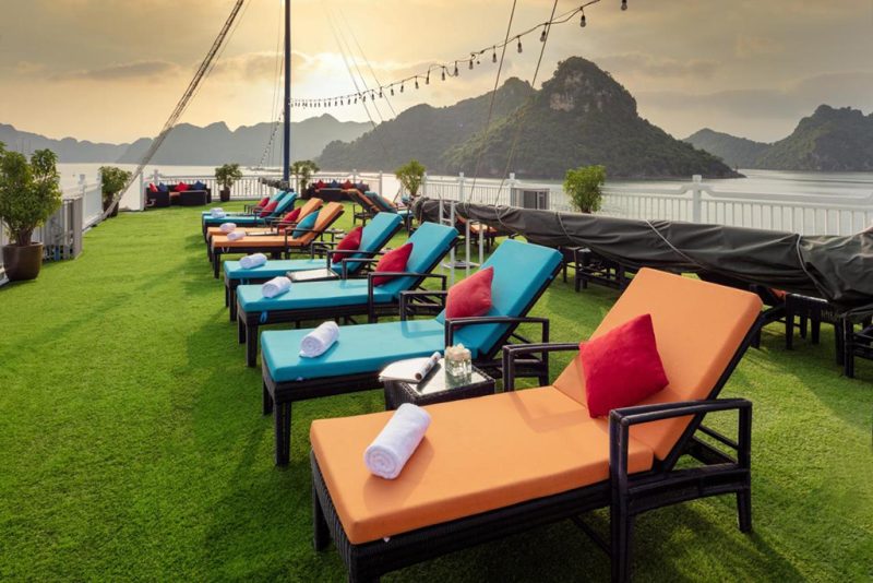 Luxurious sun deck with comfortable loungers and stunning views of Ha Long Bay on the Verdure Lotus Cruise.