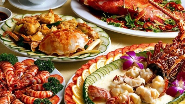 Enjoying fresh seafood at a restaurant in Ha Long Bay - Luxco Travels, Ha Long Bay tours, Vietnam, traditional squid dish.