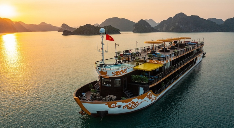 Luxurious Nostalgia Cruise sailing on Ha Long Bay during sunset