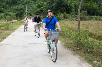Group of tourists enjoying a scenic bike ride through the countryside near Ha Long Bay