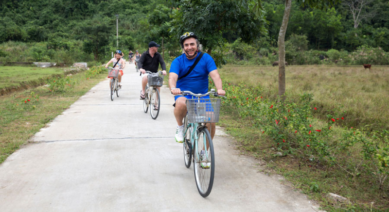 Group of tourists enjoying a scenic bike ride through the countryside near Ha Long Bay