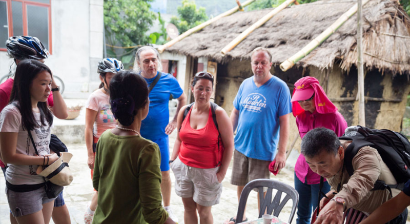 Tourists experiencing local culture in Ha Long Bay village