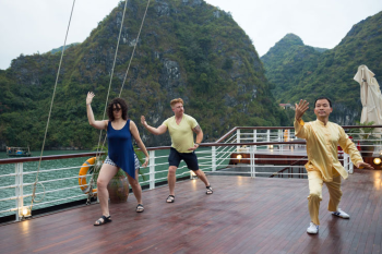 Guests practicing Tai Chi on the deck of Orchid Classic Cruise in Ha Long Bay