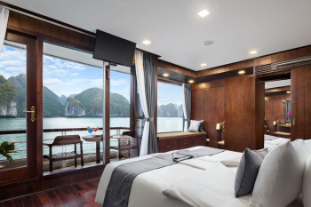 Luxurious bedroom with a balcony view on Orchid Classic Cruise in Ha Long Bay