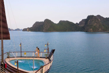 Couple enjoying the onboard pool with stunning views on the Orchid Trendy Cruise, Ha Long Bay, Vietnam - A perfect way to relax and admire the scenery