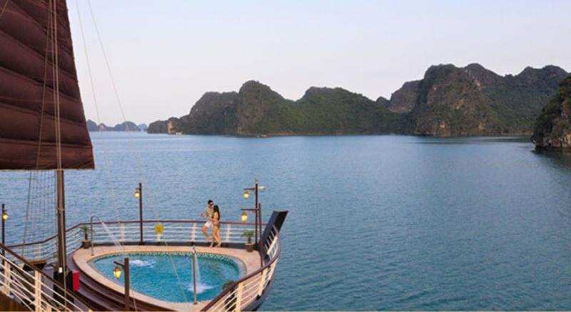 Couple enjoying the onboard pool with stunning views on the Orchid Trendy Cruise, Ha Long Bay, Vietnam - A perfect way to relax and admire the scenery