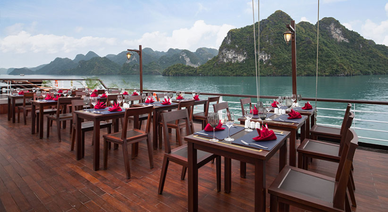 Outdoor dining area with stunning views on the Orchid Trendy Cruise, Ha Long Bay, Vietnam - Perfect for enjoying meals with breathtaking scenery