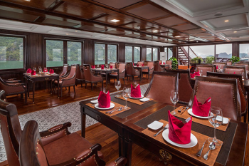 Elegant dining area with setup for fine dining on the Orchid Trendy Cruise, Ha Long Bay, Vietnam - Featuring beautiful table settings and panoramic windows