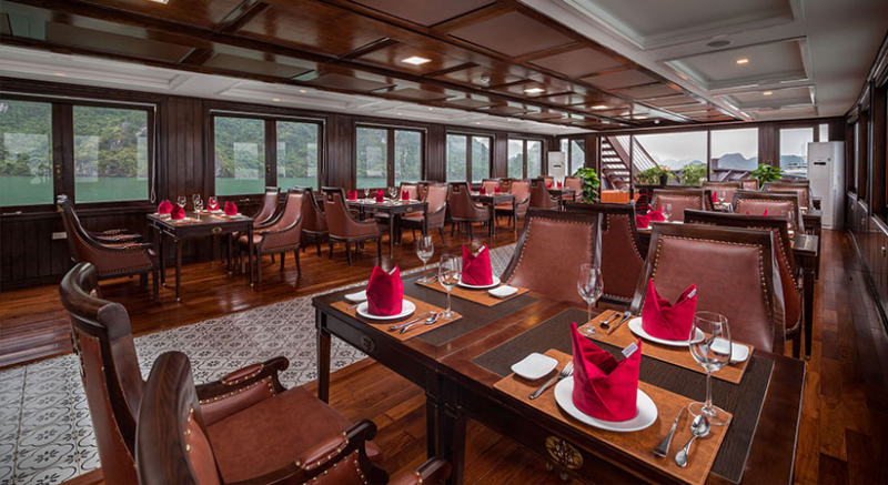 Elegant dining area with setup for fine dining on the Orchid Trendy Cruise, Ha Long Bay, Vietnam - Featuring beautiful table settings and panoramic windows