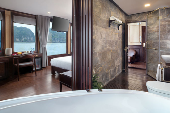 Luxurious suite with a view on the Orchid Trendy Cruise, Ha Long Bay, Vietnam - Featuring a spacious bathroom and comfortable bedroom.
