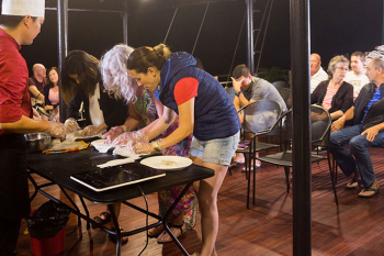 Guests participating in a cooking class on the deck of the Orchid Trendy Cruise, Ha Long Bay, Vietnam - Learning to make traditional Vietnamese dishes