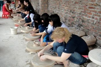 Participants learning ceramic and lacquer painting techniques at Bat Trang village, showcasing Vietnamese craftsmanship.