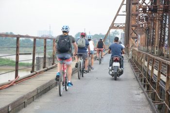 Tourists cycling through Hanoi's vibrant backstreets, exploring the city's unique charm and culture.