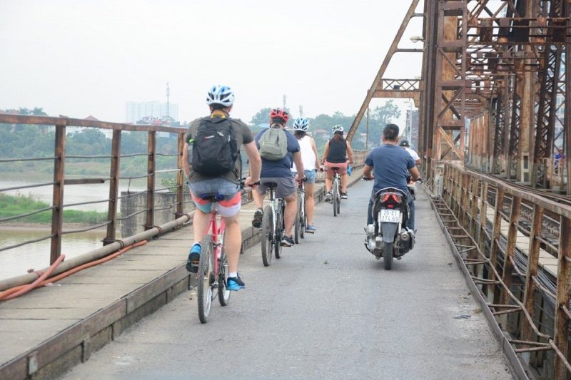 Tourists cycling through Hanoi's vibrant backstreets, exploring the city's unique charm and culture.