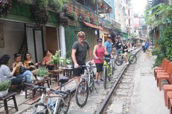 Tourists biking through Hanoi's backstreets, exploring the city's hidden gems and local culture.