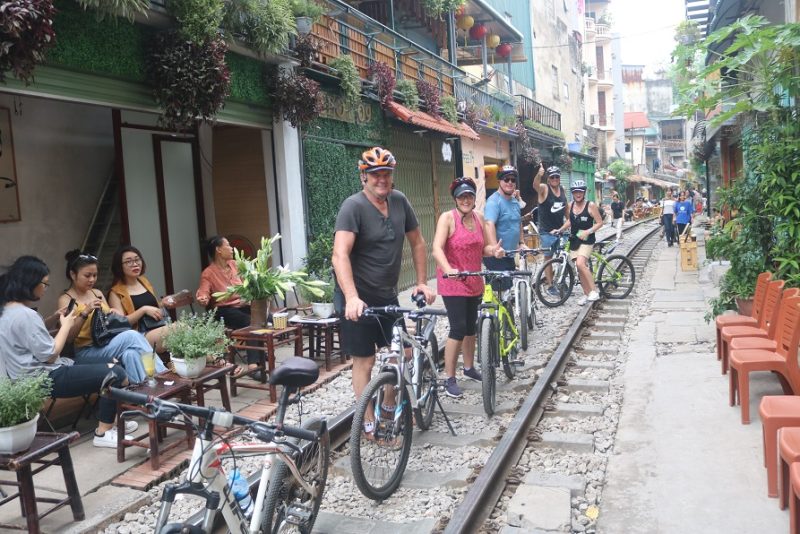 Tourists biking through Hanoi's backstreets, exploring the city's hidden gems and local culture.