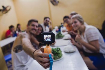 Tourists taking a group selfie in Hanoi, enjoying the vibrant nightlife and local attractions.