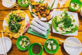 Spring rolls, grilled liver, and crispy fried noodles in Hanoi, showcasing local cuisine.