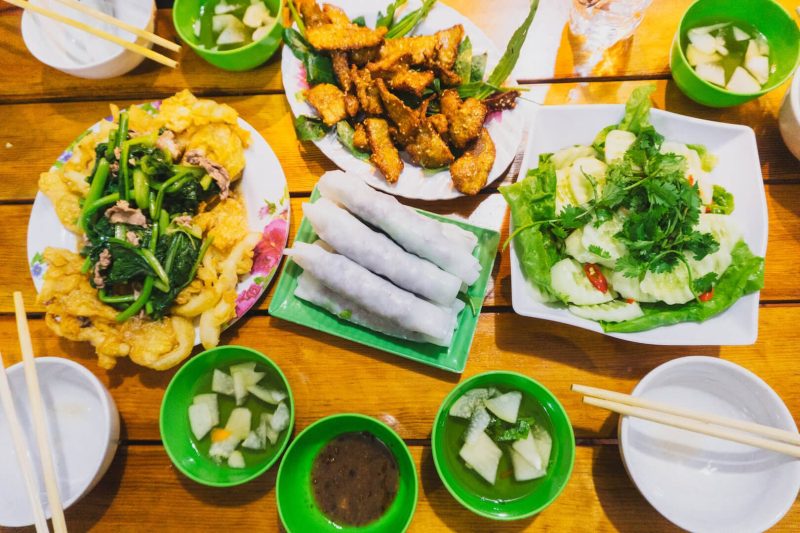 Spring rolls, grilled liver, and crispy fried noodles in Hanoi, showcasing local cuisine.