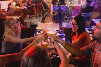 Tourists enjoying beer in Hanoi, experiencing the local nightlife and vibrant atmosphere.