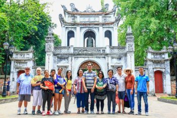 Tourists taking photos in front of the Temple of Literature in Hanoi, a historic and cultural landmark of Vietnam.