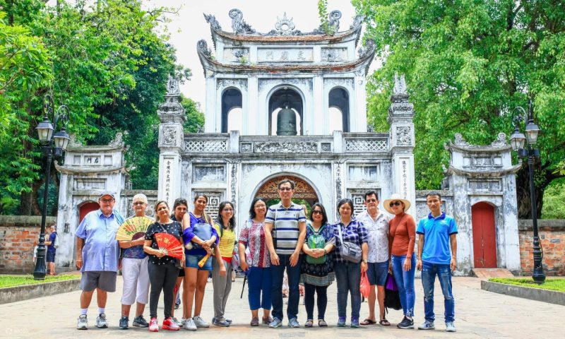 Tourists taking photos in front of the Temple of Literature in Hanoi, a historic and cultural landmark of Vietnam.
