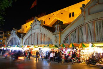 Dong Xuan Market at night in Hanoi, bustling with activity and lights, showcasing the vibrant nightlife.