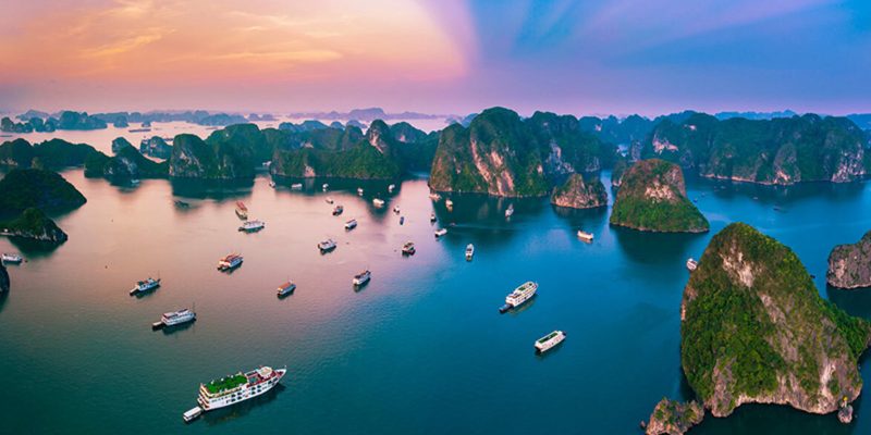 Aerial view of boats and limestone karsts in Ha Long Bay at sunset