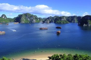 Aerial view of Ha Long Bay with boats and a sandy beach