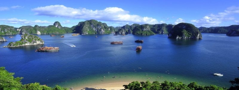 Aerial view of Ha Long Bay with boats and a sandy beach