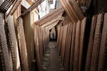 Traditional bamboo weaving in a narrow alley at Tho Ha village, showcasing Vietnamese handicraft culture.